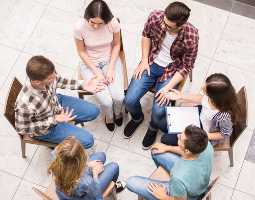 Participants engaging in a group therapy session within the PHP in Fort Worth, discussing substance use disorders